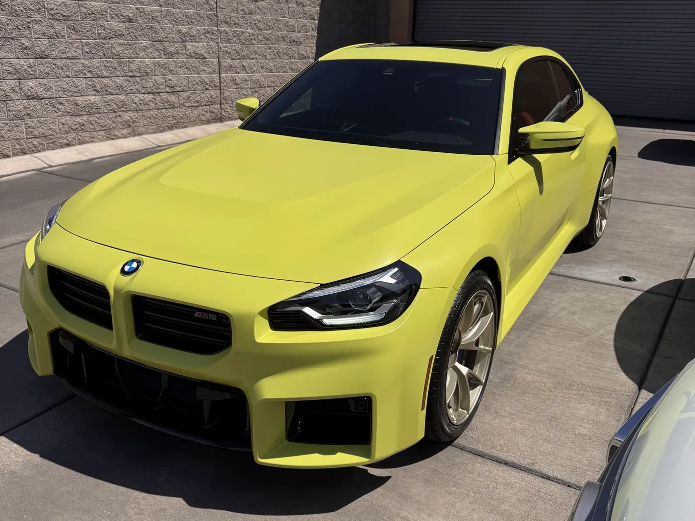 Paint protection film installed on a yellow BMW M2 by ACR Film Solutions